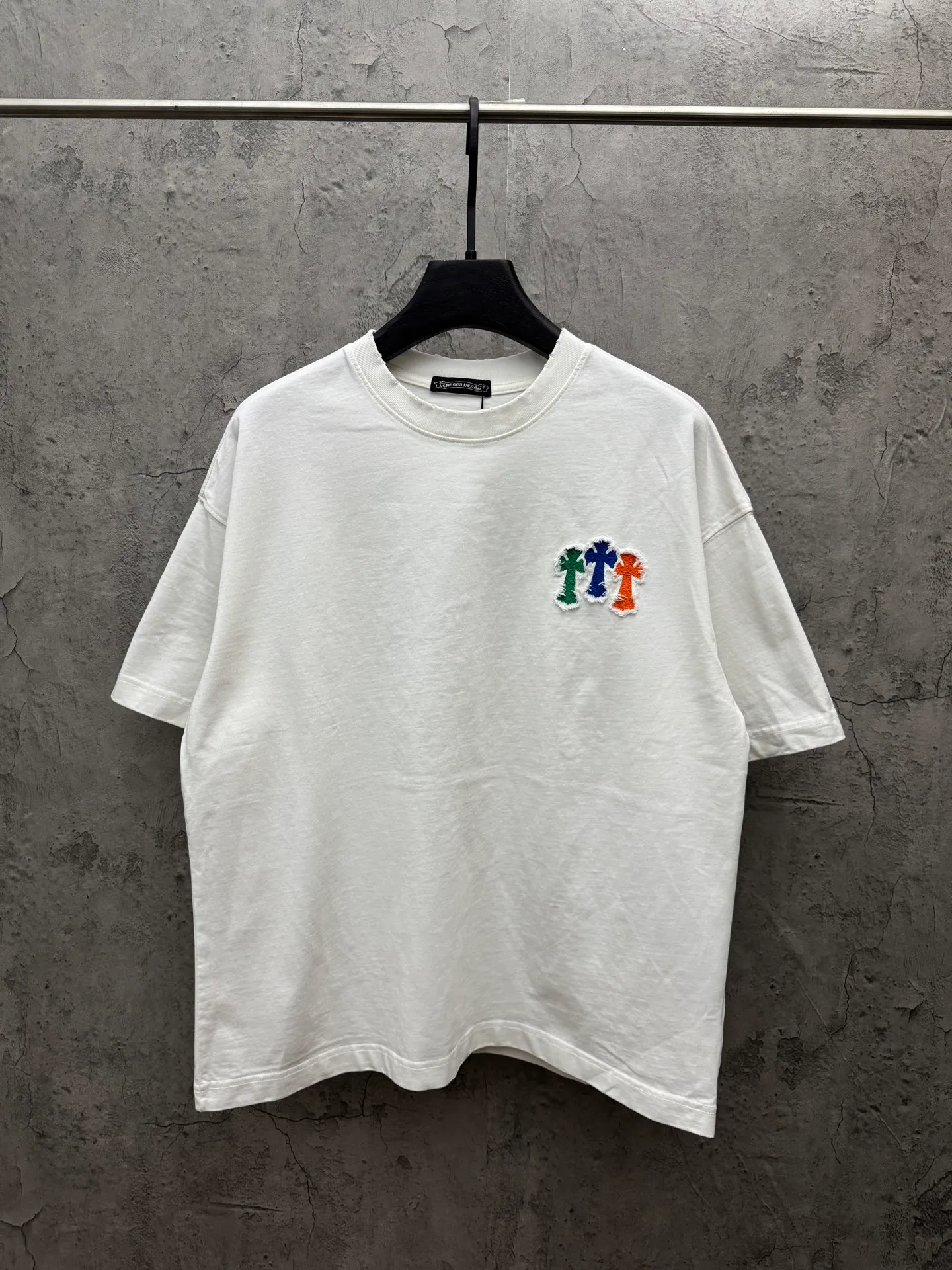 P230 top version, real shot without P, ​​different from market currency) 𝗖𝗵𝗿𝗼𝗺𝗲 𝗛𝗲𝗮𝗿𝘁𝘀/Croxin 2026 spring new original single counter American patch embroidered couple short sleeves 👑The highest version! Customized fabric 320 grams, patch embroidery, best-selling model at the counter, very comfortable to wear. Accessories: original molded and authenticated collar label ➕ 100% silk wash water label. Genuine purchase-grade original hangtag➕matching hanging rope➕3D hanging beads➕original packaging bag. Craftsmanship: The original version has consistent wiring! The highest version of the armhole matching technique! Color: White Black Size: S M L XL Style No.: 6610